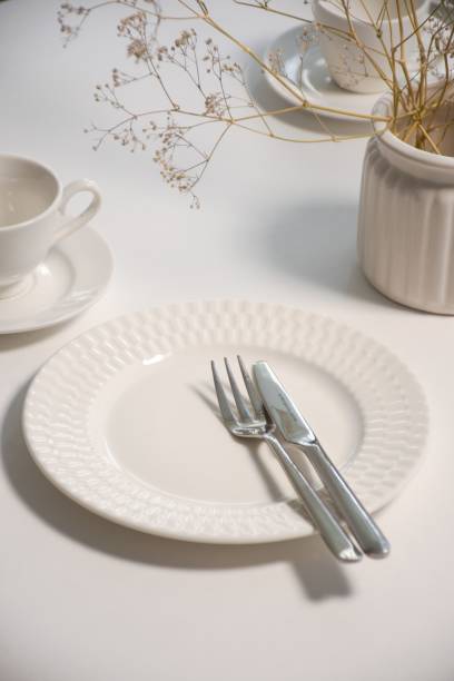 istock White ceramic plate with a stainless steel fork and a knife next to a plant. 1487268676