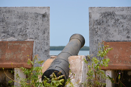 Cacheu, Guinea-Bissau: cannon bearing the coast of arms of Portugal on the ramparts Cacheu fort, , fortress located next to the mouth of the Cacheu river, first established in 1588 by Manuel Lopes Cardoso to protect the first Portuguese Factory (trading post) in the area, the current building dates from 1641‐1647, built by captain-major Gonçalo Gambôa de Ayalla.