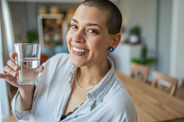 istock Young woman in the kitchen drinking water 1487273630