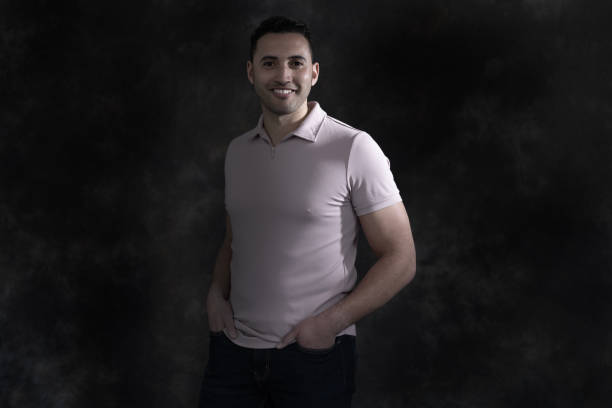 istock Spotlit Man on a Dark Background Smiling 1487273922