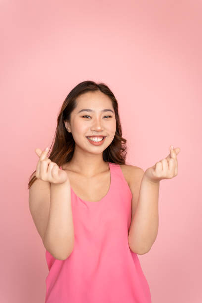 istock Woman makes korean heart gesture with her hands. 1487275024
