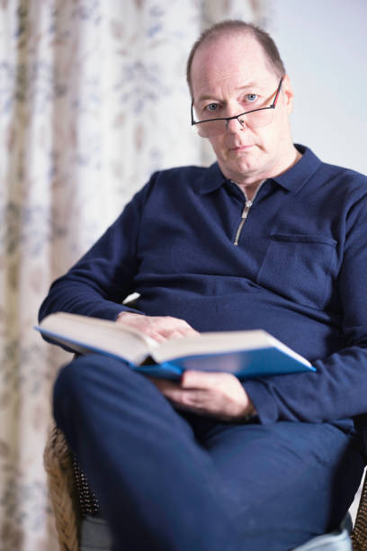 istock Man aged 60 reading at home 1487275353