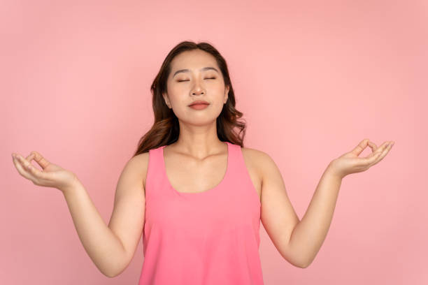 istock A woman meditates in a zen-like studio shot. 1487275643