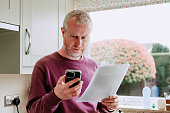 Man paying bills using smart phone at home
