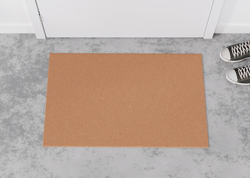 Blank brown door mat on the floor at home. Welcome mat with copy space for your text. Doormat mock up. Carpet at entrance for wiping dirty shoes. Mockup. 3D Rendering