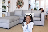 Hiding, counting and family playing a game in the living room for bonding, quality time and fun. Together, playful and child covering her eyes for hide and go seek with parents and siblings in lounge