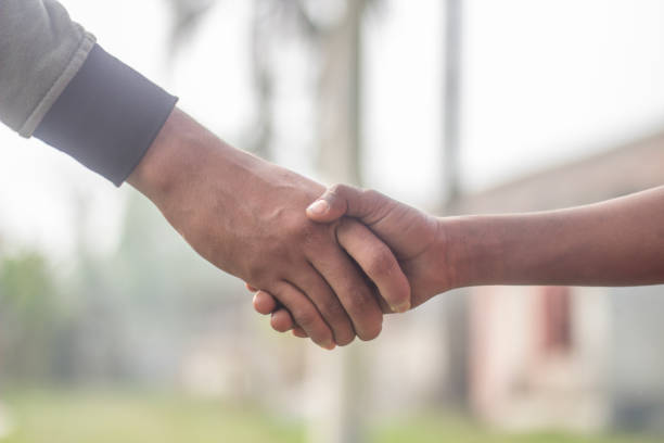 istock Two hands are holding the handshake together and the background is blurred 1487278507