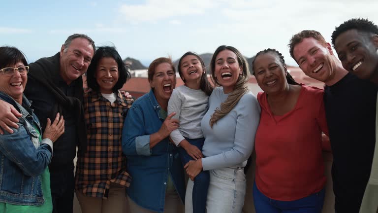 Group of multigenerational friends smiling in front of camera - Multiracial friends of different ages having fun together