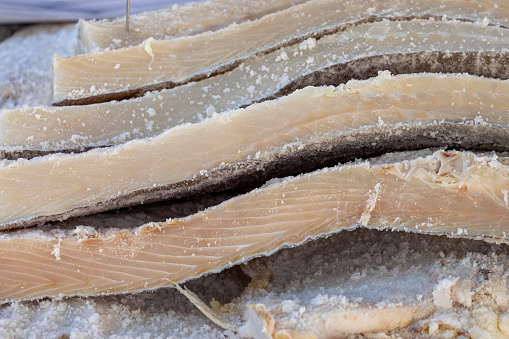 Several strips of quality salted cod in a street market. The salting that consists of drying it with salt.