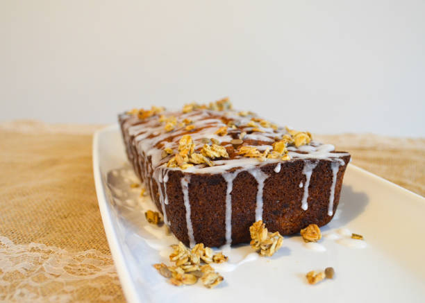 Loaf of lemon drizzle cake with icing and granola topping from the corner stock photo
