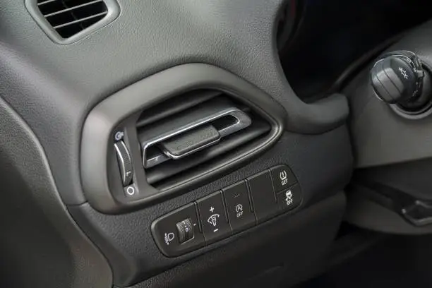 Air vent grill in a car. Air conditioner grid and control panel buttons.