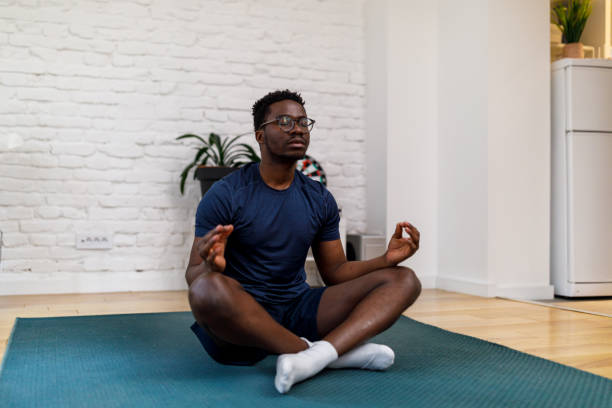 istock A young African man is doing yoga exercises at home. 1487282308