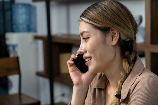 istock Happy Young woman talking on smartphone at home 1487282430