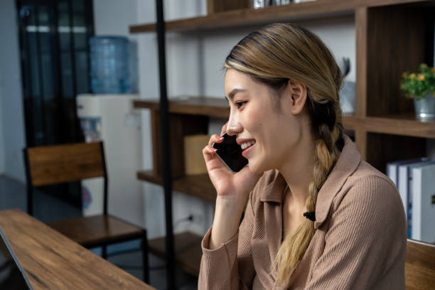 istock Happy Young woman talking on smartphone at home 1487282434