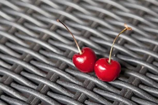 two red cherries on a black table