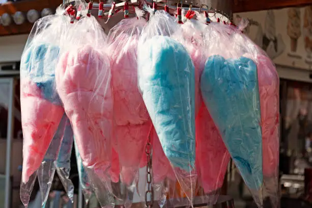pink and blue cotton candy for sale in a street stall