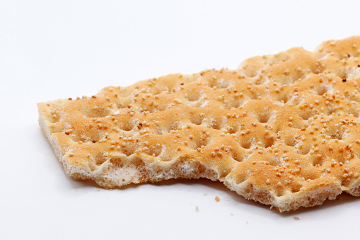 hard crispbread with crumbs and seeds on white background