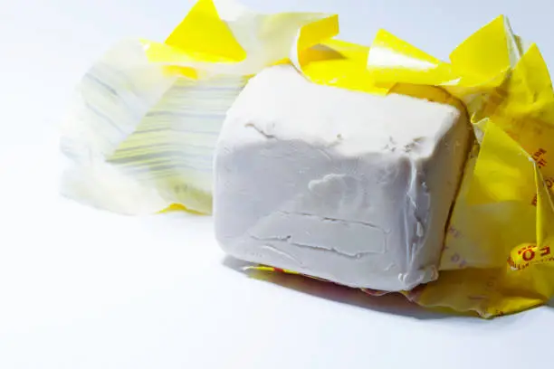 an opened package of yeast on a white background