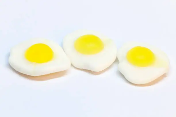 three pieces of fried candy eggs on a white background