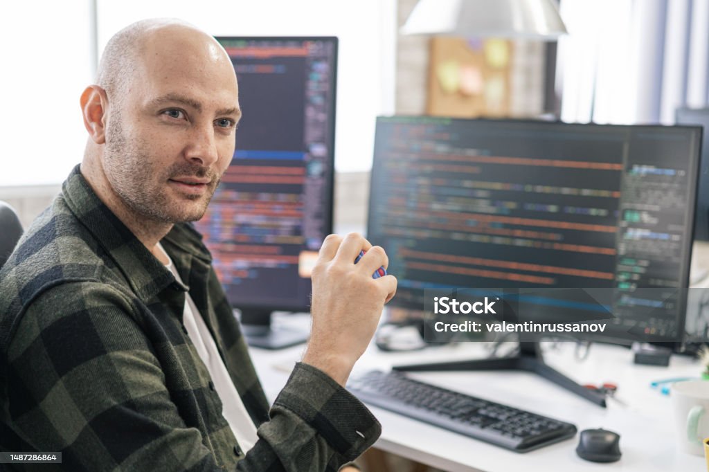 Portrait Of Smiling It Programmer Sitting Near Desktop Computers Male ...