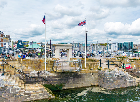 Plymouth, UK. 2 April 2023. People walking around the landmark, Mayflower Steps Memorial in Sutton Harbour, Plymouth
