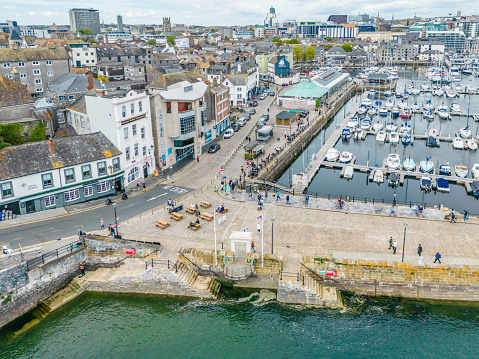 Plymouth, UK. 2 April 2023. People walking around the landmark, Mayflower Steps Memorial in Sutton Harbour, Plymouth
