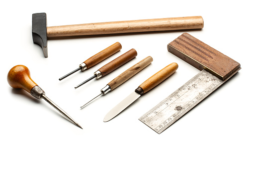 Hammer, awl, try square and gouges with wooden handles on a white background with copy space