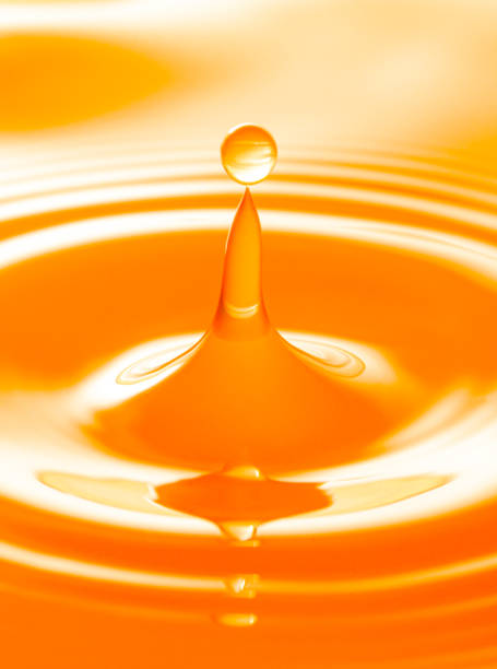istock macro orange drop,Macro orange water drop texture,Falling drop in orange water with splash,The waves after a few drops of orange juice. 1487289933