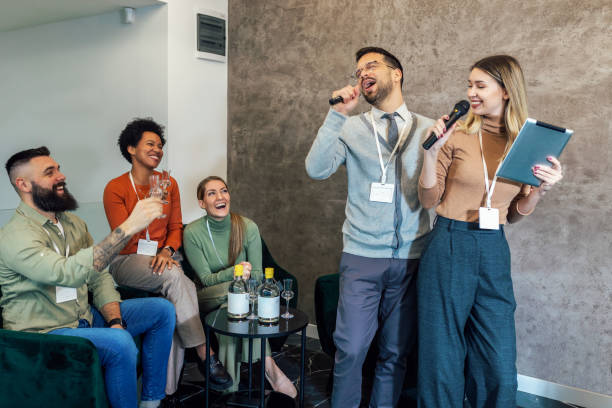 istock Business people singing karaoke in modern office 1487290011