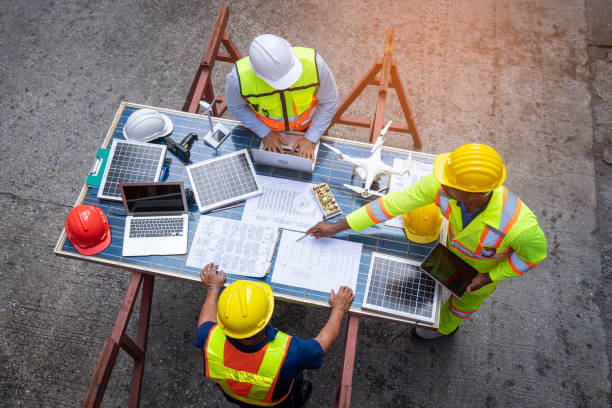 Top view of team engineer working on solar panel and his blueprints with Solar photovoltaic equipment on construction site. stock photo
