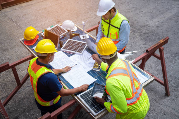 istock Top view of team engineer working on solar panel and his blueprints with Solar photovoltaic equipment on construction site. 1487290035