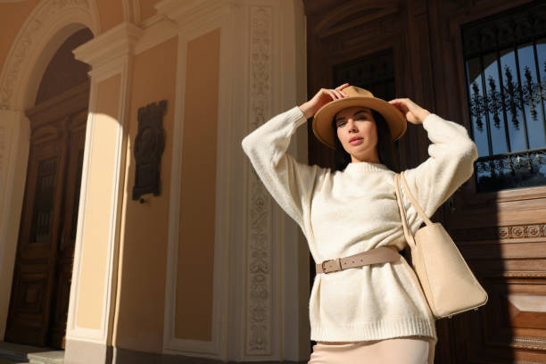 jeune femme avec sac élégant à l’extérieur du beau bâtiment, vue en contre-plongée. espace pour le texte - belt leather fashion women photos et images de collection