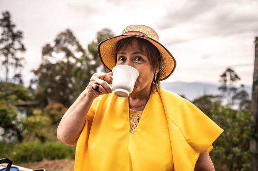 Mature woman drinking coffee on agricultural field