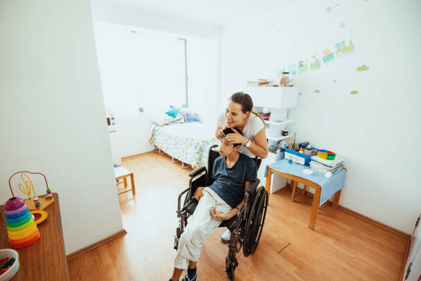 istock Working in nursery with children with learning difficulties - Boy in wheelchair with Celebral Palsy 1487293786