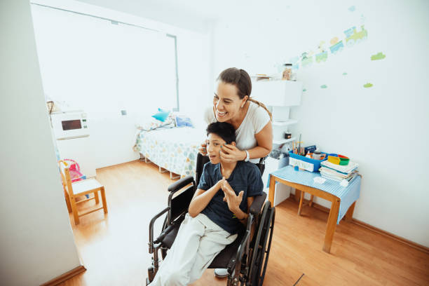 istock Working in nursery with children with learning difficulties - Boy in wheelchair with Celebral Palsy 1487293787