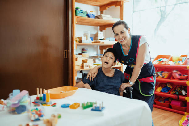 istock Working in nursery with children with learning difficulties - Boy in wheelchair with Celebral Palsy 1487293859