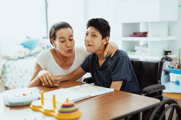 istock Children with disabilities learning better with parents. Woman and boy learning together 1487293896
