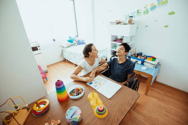 istock Working in nursery with children with learning difficulties - Boy in wheelchair with Celebral Palsy 1487293902