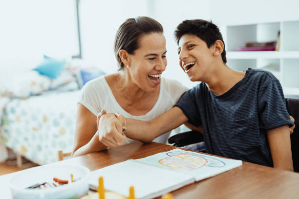 istock Children with disabilities learning better with parents. Woman and boy learning together 1487293940