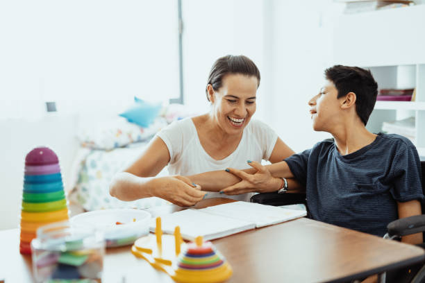 istock Working in nursery with children with learning difficulties - Boy in wheelchair with Celebral Palsy 1487293974