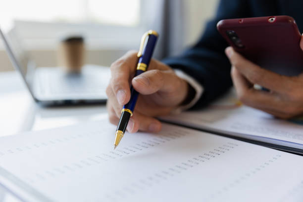 istock Asian businessman working at office with laptop, tablet and graph data sheet on his desk. 1487297158