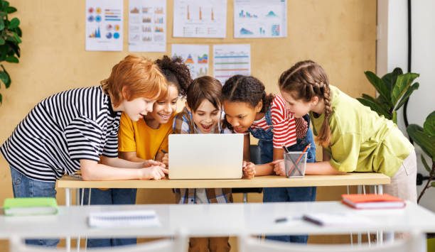 istock Cheerful  schoolkids   looking at laptop screen and celebrate   successful completion of collective school work   during online lesson 1487297910
