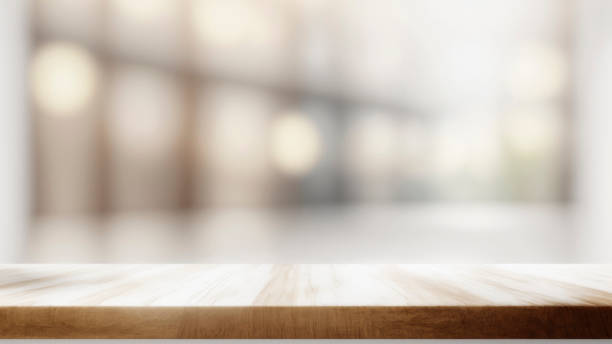 istock wooden table top with blurred white blur defocused background. Mock up 1487299394