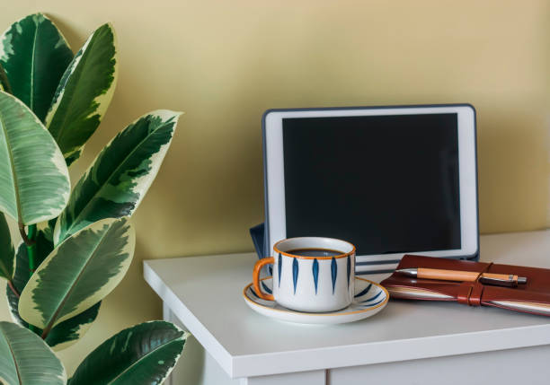 Home interior - coffee break, tablet and a cup of coffee on the table in the living room