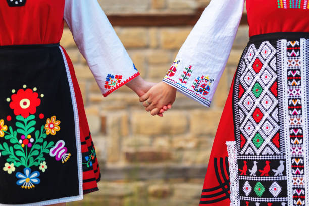 Girls in traditional bulgarian ethnic costumes with folklore embroidery holding hands. The spirit of Bulgaria - culture, history and traditions. stock photo