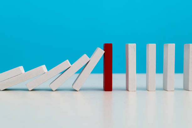 istock Red wooden block stop other falling dominos 1487303904