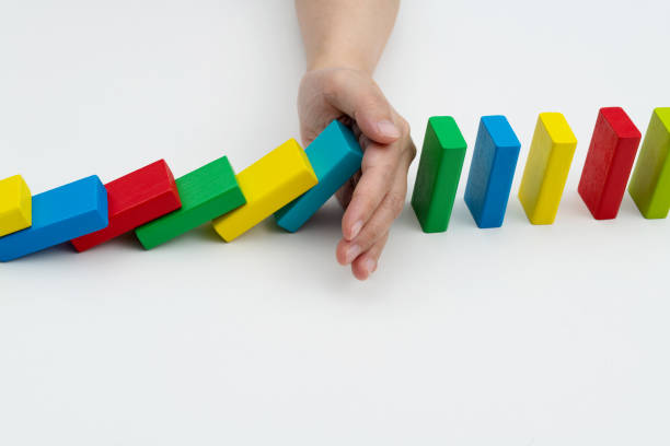 Woman hand stopping the dominos falling
