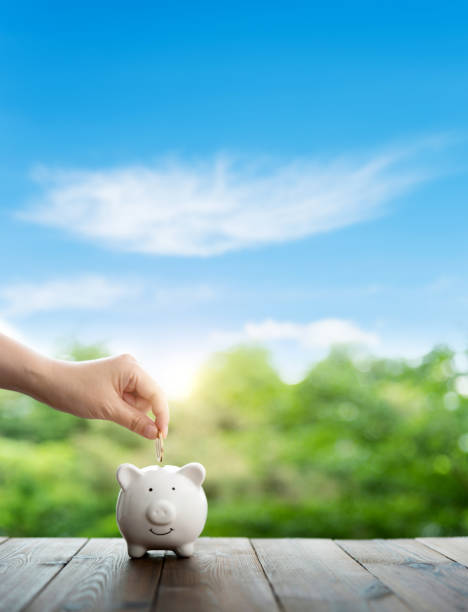 istock Human hand putting coin into piggy bank 1487304575
