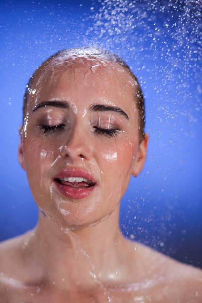 Woman being splashed with water Young woman after splash of water from top. shower women falling water human face stock pictures, royalty-free photos & images
