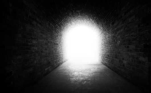 Old brick tunnel with a light at the end